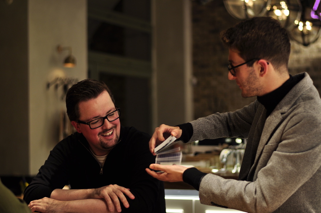 Magicien close-up invitant un spectateur à choisir une carte lors d'un événement