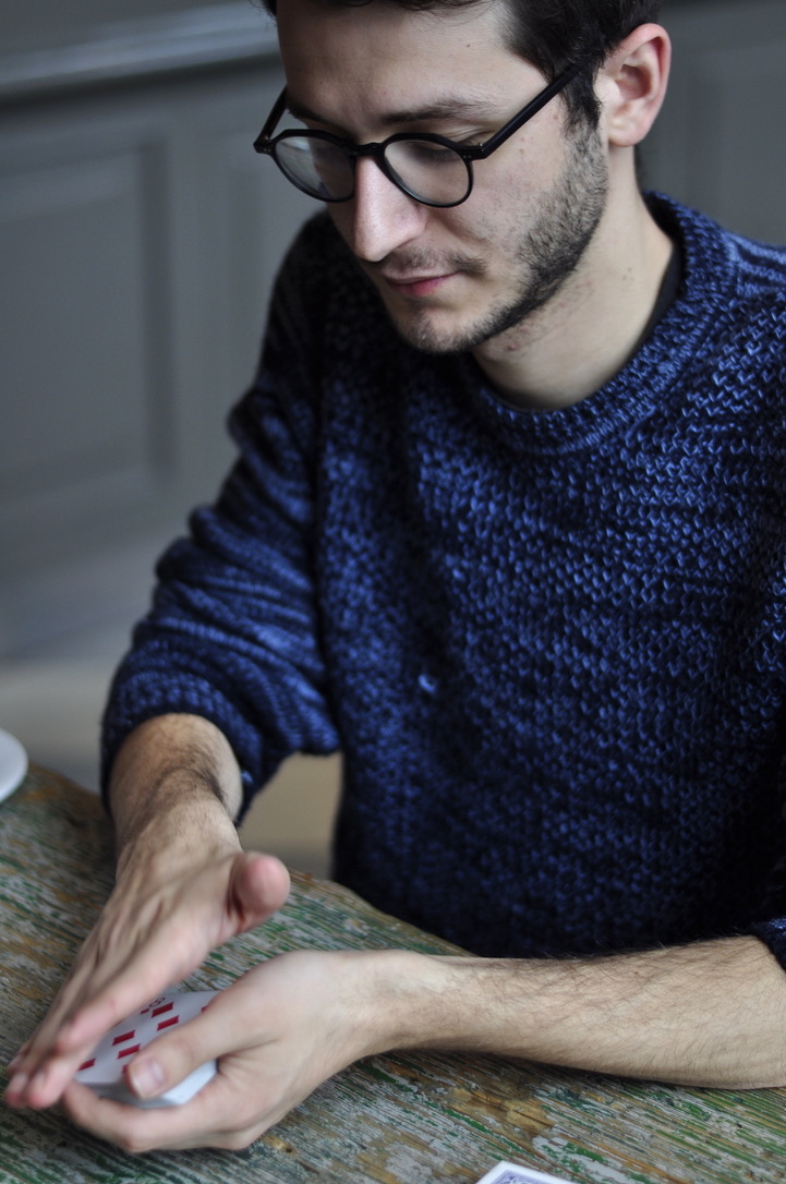 Magicien réalisant une manipulation de cartes complexe (empalmage)